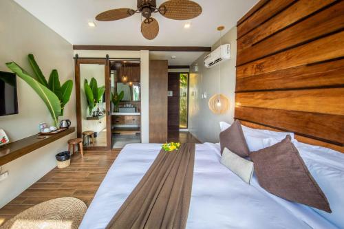 um quarto com uma cama grande e uma cabeceira em madeira em Ahana Resort El Nido em El Nido