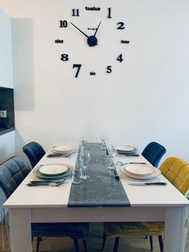 a table with chairs and a clock on a wall at Luxurious Apartment Private Parking 25 MN to Paris in Yerres