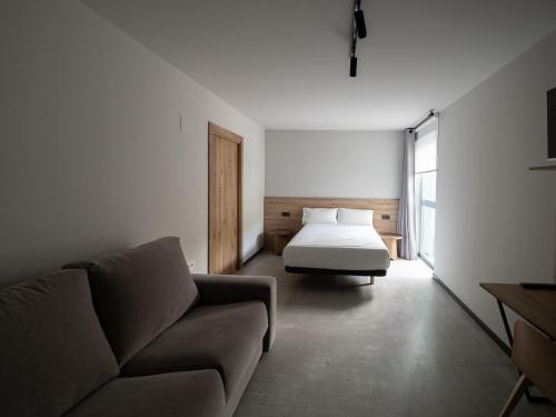 ein Wohnzimmer mit einem Bett und einem Sofa in der Unterkunft Casa rural Goiko Errota landetxea in Arrasate - Mondragon