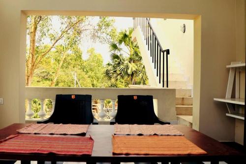 ein Esszimmer mit einem Tisch und einem großen Fenster in der Unterkunft Luxury Villa Siena with Private Pool! in Puducherry