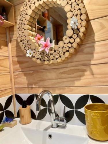a bathroom sink with a mirror above a sink at Are Mii a stylish one room container home in Rarotonga