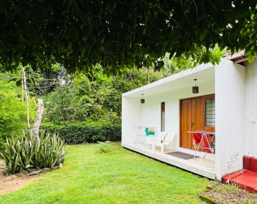 a small white house with a yard at The Loft in Midigama