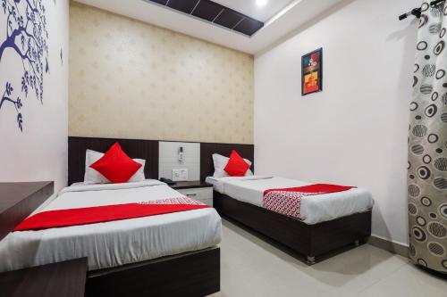 two beds in a room with red pillows at OYO Ssr Luxury Rooms in Lingampalli