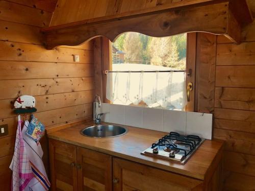 - une cuisine avec évier et cuisinière dans une cabine dans l'établissement Relax in Baita di montagna!, à Pieve di Cadore