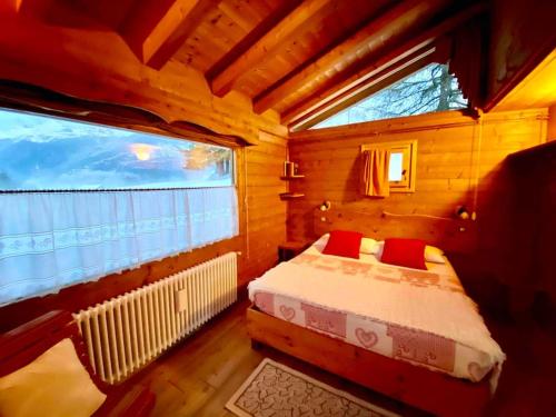 une petite chambre avec un lit et une fenêtre dans l'établissement Relax in Baita di montagna!, à Pieve di Cadore