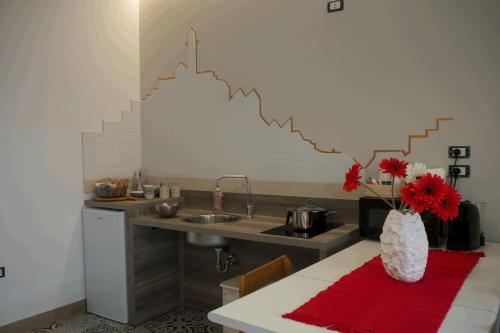 a kitchen with a sink and a table with a vase of flowers at dimora Spine Bianche in Matera