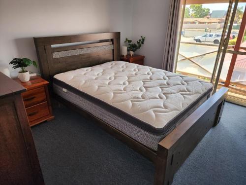 a large bed in a room with a window at Cosy 2 bedroom Unit in a secure gated complex in Kalgoorlie