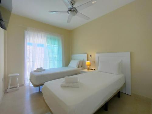 a bedroom with two beds and a window at Spacious Apartment With Private Jacuzzi and Pool Access in Puerto Rico de Gran Canaria