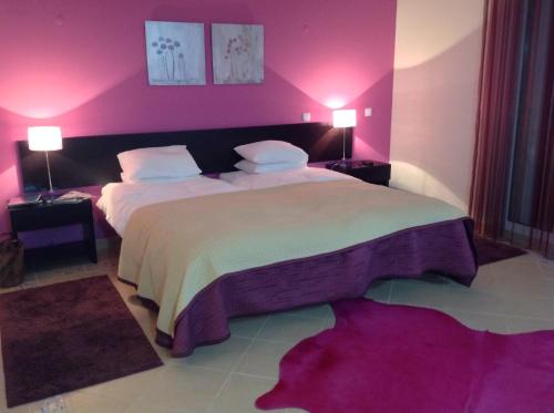 a bedroom with a large bed with pink walls at Villa Castro Marim in Castro Marim