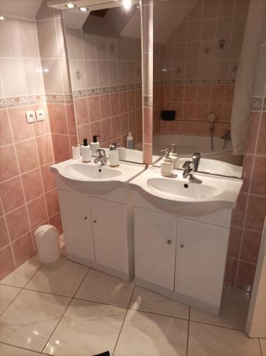 une salle de bain avec deux lavabos, un miroir et une baignoire dans l'établissement Schumann Balcon Vannes, à Vannes