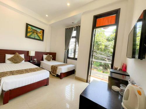 a hotel room with two beds and a large window at Riverlife Homestay in Hoi An