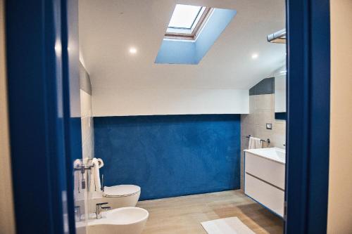 a bathroom with a toilet and a sink and a skylight at Karma Resort in Venetico