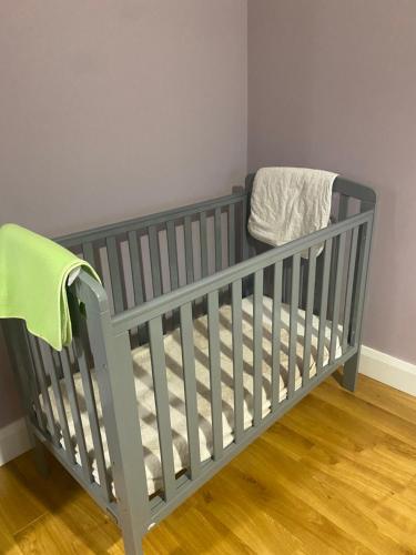 a grey crib in a room with wooden floors at Big Anthony’s in Greencastle