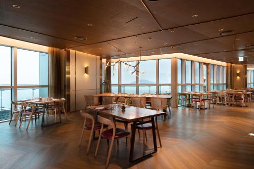 a restaurant with tables and chairs and large windows at Signiel Busan in Busan