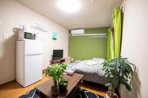 a room with a bed and a table with plants at Minimalism HOTEL TOKYO Katsushika in Tokyo