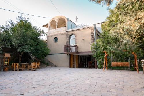 ein Haus mit einem Balkon und einer Terrasse in der Unterkunft EleGaya Guest house in Idschewan