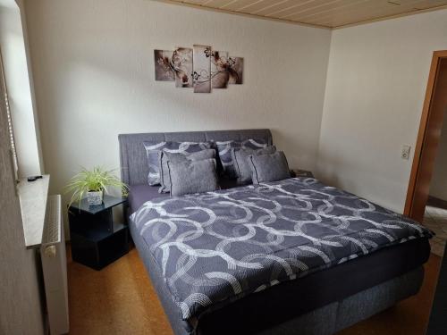 a bedroom with a bed with a gray comforter and pillows at Ferienwohnung Moselzeit in Alken