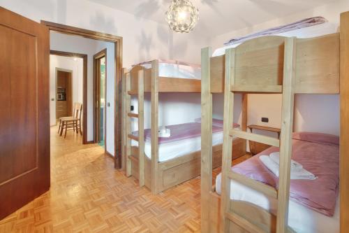 a room with three bunk beds and a hallway at Casa Rossella in Bormio