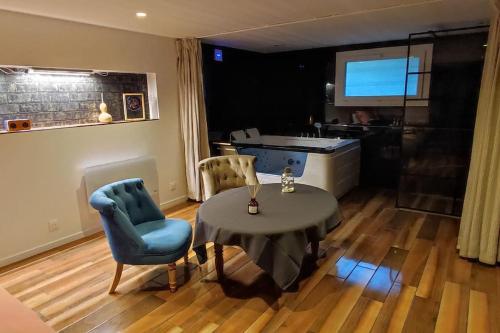 un salon avec une table et des chaises et une cuisine dans l'établissement Studio paisible et balnéo, à Vezin-le-Coquet