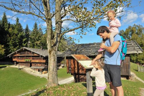 a man with a child on his back and a house at Sunny Mountain in Münster
