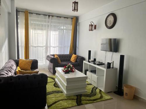 a living room with two couches and a table at Zoe Homes Greypoint 1br and 2br Apartment 101 in Kericho