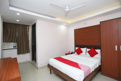 1 dormitorio con 1 cama grande con almohadas rojas en Kamat Inn, en Bankipur