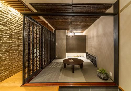 un pasillo con una mesa en una habitación con una pared de ladrillo en villa-rizo 山田, en Takayama