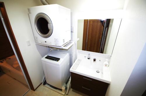 een badkamer met een wastafel en een wasmachine bij Plage Garden Place　A-101 in Miyako Island