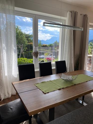 a dining room table with chairs and a large window at Appartement Christine in Eben im Pongau