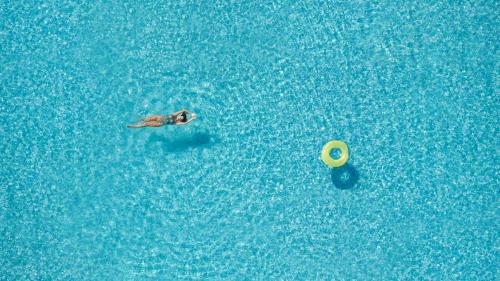 a person swimming in the water with a frisbee at Little Bird Lesvos in Petra