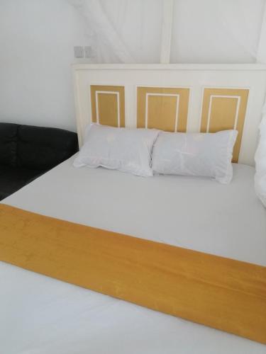a bed with white sheets and white pillows at Mombasa City Center Studio in Mombasa