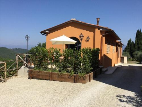 a building with an umbrella on the side of a road at Podere Capitignano in Borgo San Lorenzo