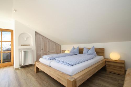 - une chambre avec un lit doté d'oreillers bleus et blancs dans l'établissement Apartment Jenny, à Garmisch-Partenkirchen