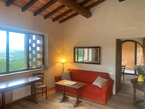 a living room with a red couch and a table at Podere Capitignano in Borgo San Lorenzo