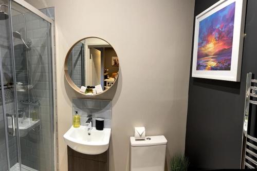 uma casa de banho com um lavatório e um espelho em Luxury In Loughborough em Loughborough