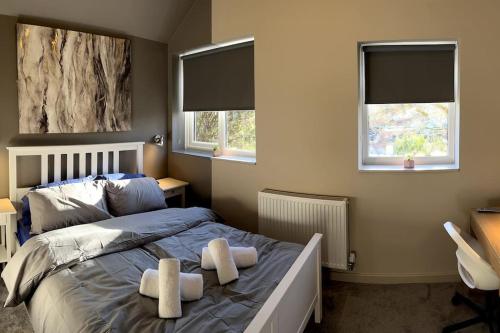 a bedroom with a large bed with two windows at Luxury In Loughborough in Loughborough