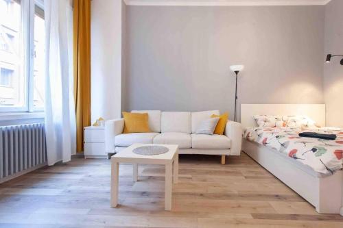 a white living room with a couch and a table at Budapest City Centre Studio - Contactless Check In in Budapest