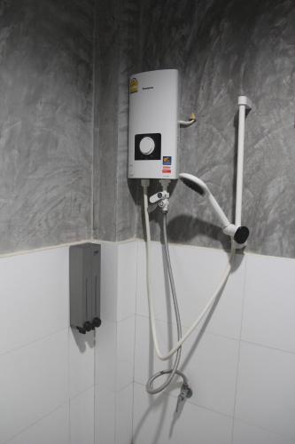 a white soap dispenser on a wall in a bathroom at Yangyai Garden Lodge in Baan Tai