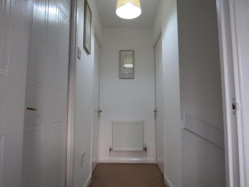 um corredor com paredes brancas e uma porta em Remarkable and perfect 3 Bed House in Nottingham em Nottingham