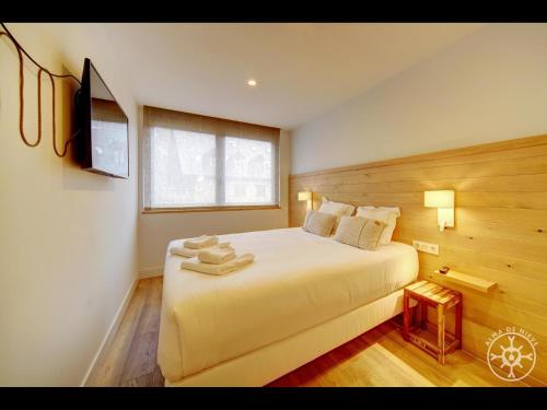 a bedroom with a large bed with a television on the wall at SANTA MARGALIDA de Alma de Nieve in Bagergue