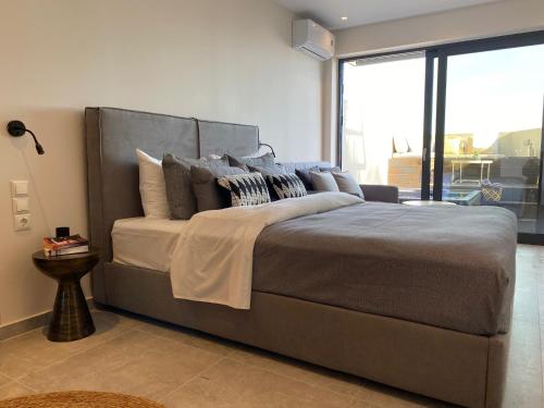 1 cama grande en un dormitorio con ventana grande en Skiathos Gea Villas, en Achladies