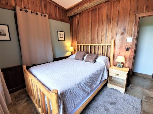 a bedroom with a bed and a wooden wall at Its Owl Good in Luray