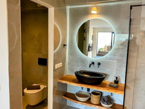 ein Bad mit einem Waschbecken und einem Spiegel in der Unterkunft Skiathos Gea Villas in Achladies