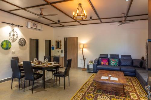 a living room with a table and a couch at SaffronStays Apricus Farm, Karjat in Karjat
