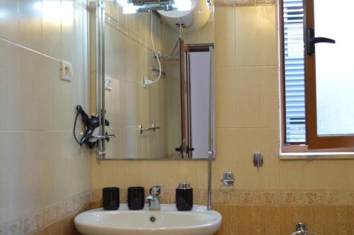 a bathroom with a sink and a mirror at RH Tirana Center in Tirana