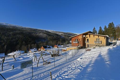 a ski lodge in the snow next to a building at Hotel Jirinka in Dolní Morava