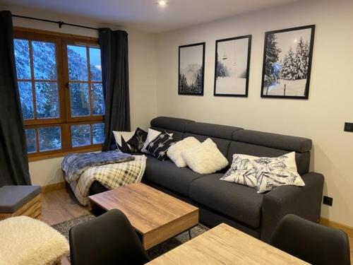 a living room with a couch and a bed at Arcs 1950 Appartement prestige Ski InOut 6 pax in Bourg-Saint-Maurice