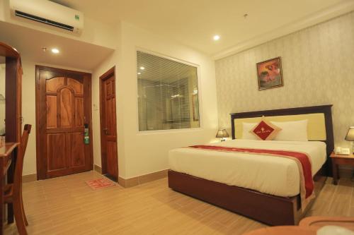 a bedroom with a large bed and a window at Hoang Son Hotel - Can Tho in Can Tho