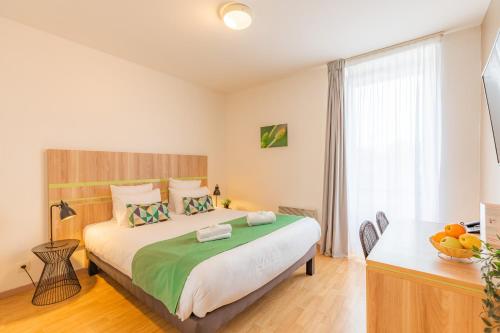 a bedroom with a large bed and a desk at Appart’City Confort Nantes Centre in Nantes