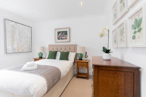 Beautiful 4 Bedroom Home في تشلتنهام: غرفة نوم بسرير وطاولة خشبية